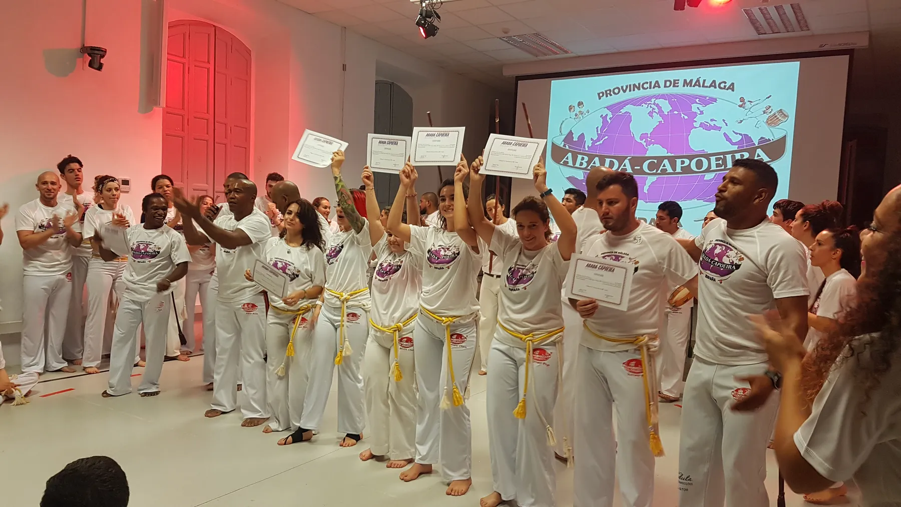 Alumnos y alumnas de la escuela con sus diplomas y cordas nuevas al terminar un batizado